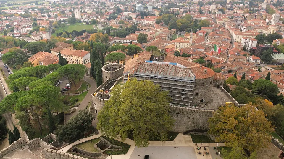 Il Castello dall'alto, con i ponteggi e i teli sul tetto, e dietro il centro di Gorizia.