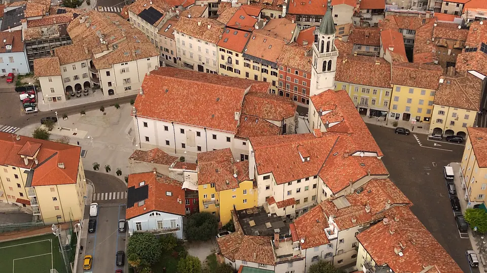 Il centro di Gorizia dall'alto: tetti in coppi, facciate colorate e un campanile.